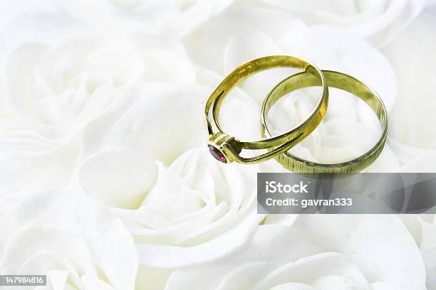 Two Wedding Rings Over White Roses Stock Photo - Download Image Now - Beauty, Decoration, Elegance