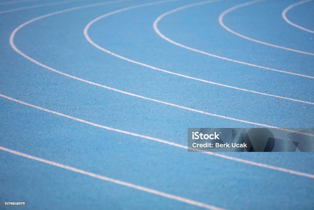 Blue athletics track. An all-weather running track is a rubberized, artificial running surface for track and field athletics. It provides a consistent surface for competitors to test their athletic ability unencumbered by adverse weather conditions. Backgrounds Stock Photo