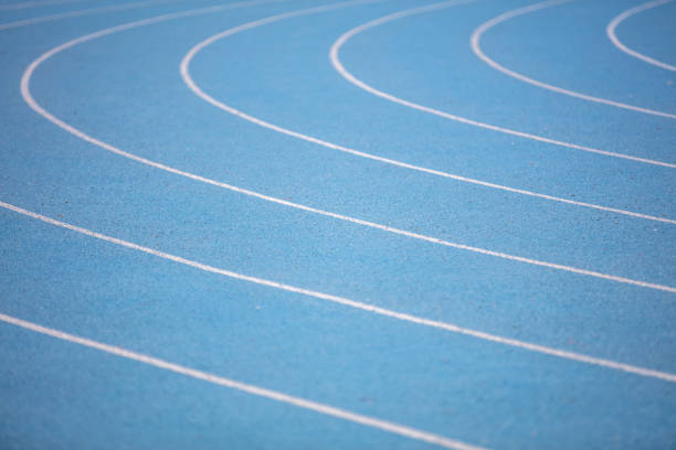 Blue athletics track. An all-weather running track is a rubberized, artificial running surface for track and field athletics. It provides a consistent surface for competitors to test their athletic ability unencumbered by adverse weather conditions. berk stock pictures, royalty-free photos & images