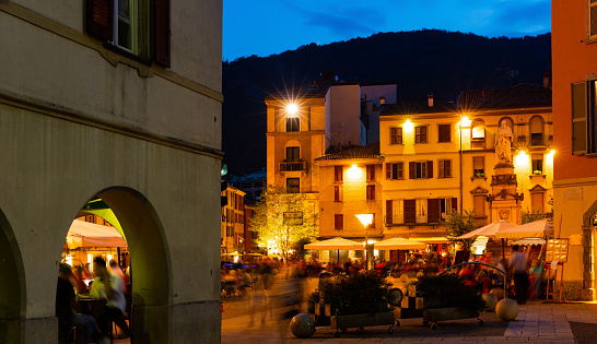Busy nightlife of illuminated central Como streets in summer, Italy