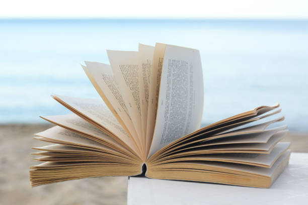 istock Open book on white table near sea 1479858208