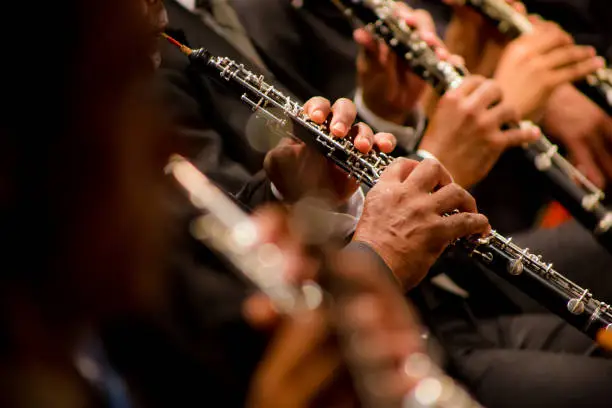 black hands playing clarinets in orchestra