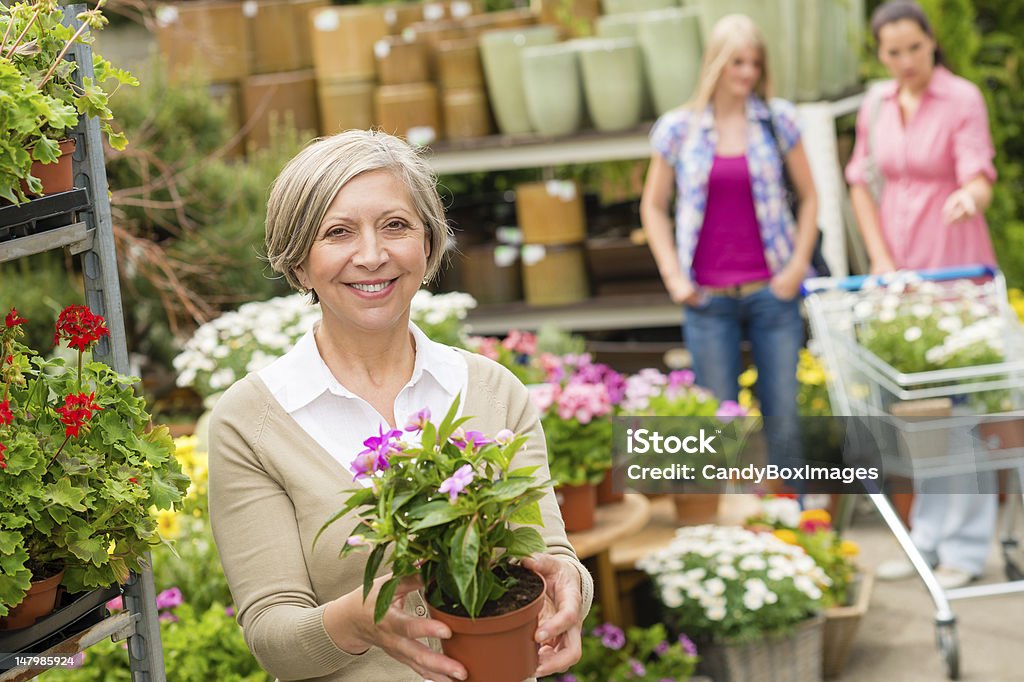 Jardinerie senior femme tenir en pot de fleur - Photo de Adulte libre de droits