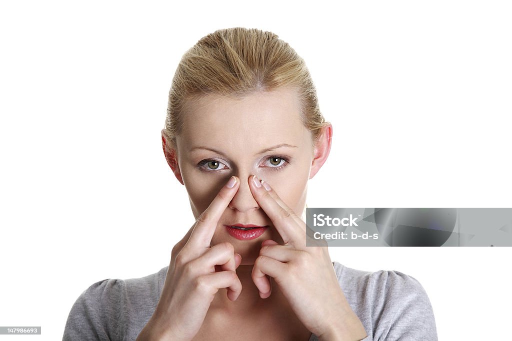 Woman with hands over her nose feeling pain Woman holds the bridge of her nose suffering from sinus pain. One Woman Only Stock Photo