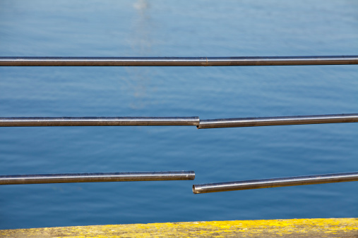 Broken stainless steal railing with slippery floor facing the sea