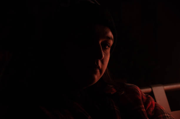 istock A woman's face glows out of the darkness 1479873085