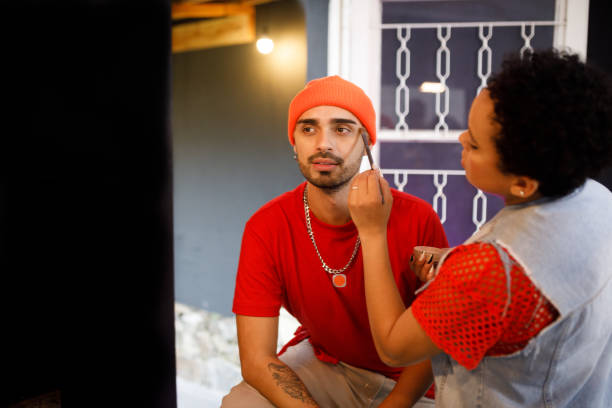 istock Curly haired woman applying make up on her boyfriend 1479874827