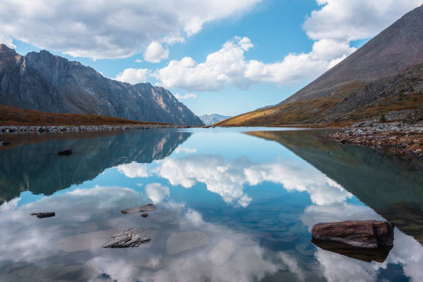 mysterious lake in the mountains with reflected sky covered with mist