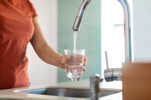 Unrecognizable Woman Filling Glass With Water From Tap In Kitchen, Thirsty Young Female Pouring Healthy Liquid At Home, Taking Care Of Body Hydration, Enjoying Refreshing Drink, Cropped Shot