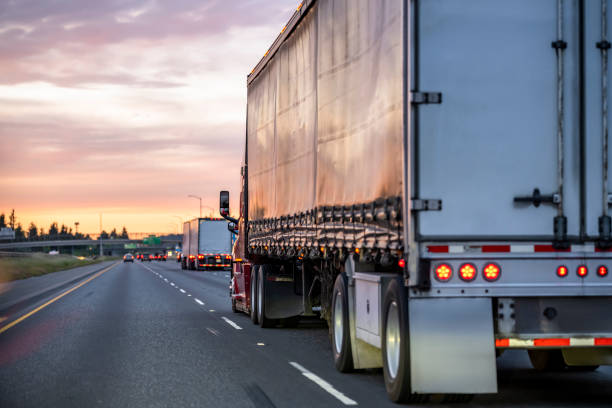 borgogna grande rig semi camion con semirimorchio coperto nero che guida sulla strada autostradale al crepuscolo con cielo nuvole rosa - covered truck foto e immagini stock