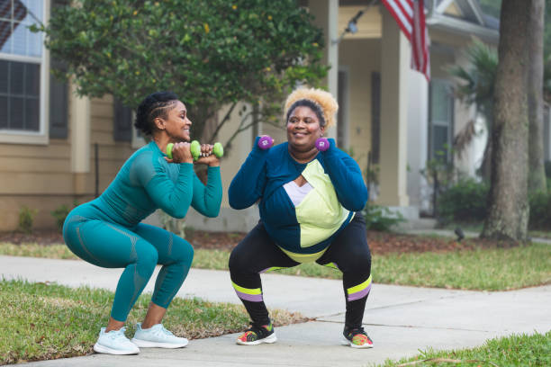 istock Two African-American women exercising, doing squats 1479895426