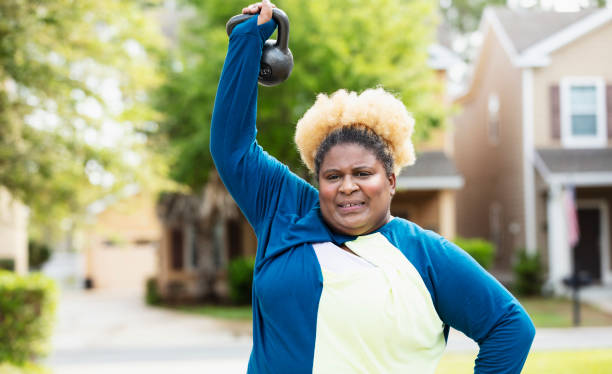 istock African-American woman exercising, lifting kettlebell 1479895523