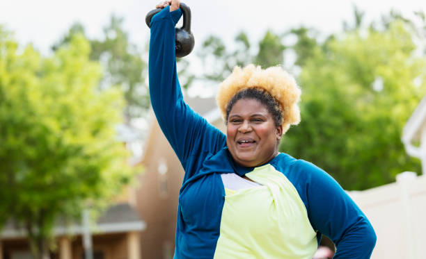 istock African-American woman exercising, lifting kettlebell 1479895525