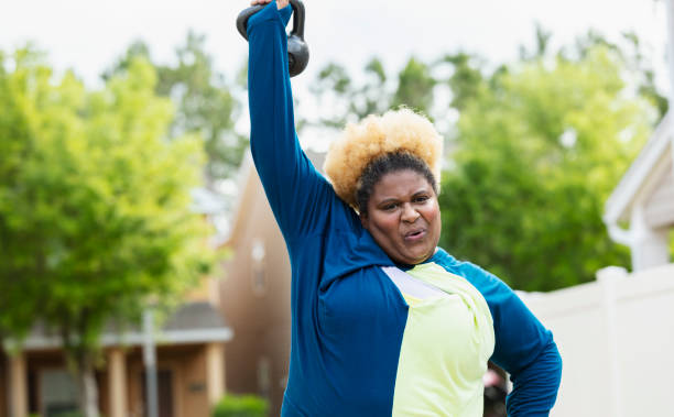istock African-American woman exercising, lifting kettlebell 1479895529