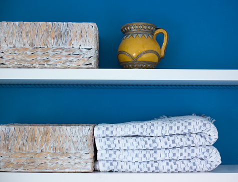 Home Decor with White Wicker Baskets, Blue Wall, Bath Towels