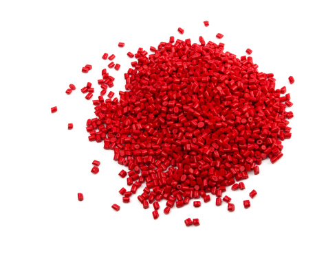Pile of red plastic granules isolated on white