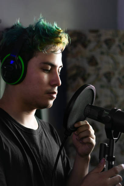 istock Latin young man adjust the microphone's pop filter 1479898850