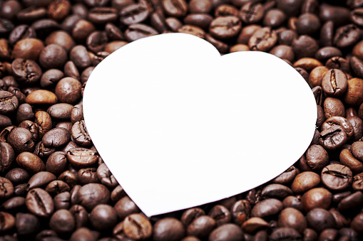 Roasted coffee beans with heart shape background.