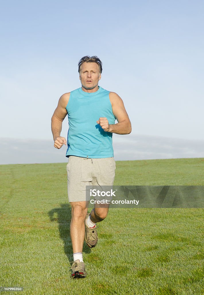 Uomo jogging in camicia blu - Foto stock royalty-free di Abbigliamento sportivo