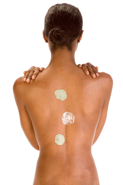 Back of black woman with multicolored cream patch Body care - African American female torso with three types of skincare product (moisturizer) applied on it slicked back hair stock pictures, royalty-free photos & images