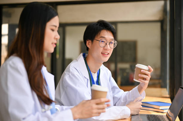 istock Two Asian doctors are having a quick lunch break at a cafe, talking and having coffee together. 1479908647