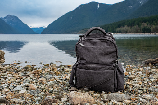 Backpack on the mountain and lake background. Scenic nature on mountain in Canada with backpack. Nobody, travel photo, selective focus