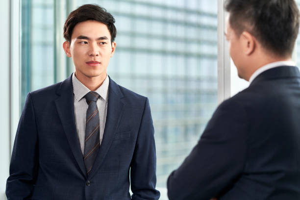 istock two asian businessmen chatting in office 1479913580