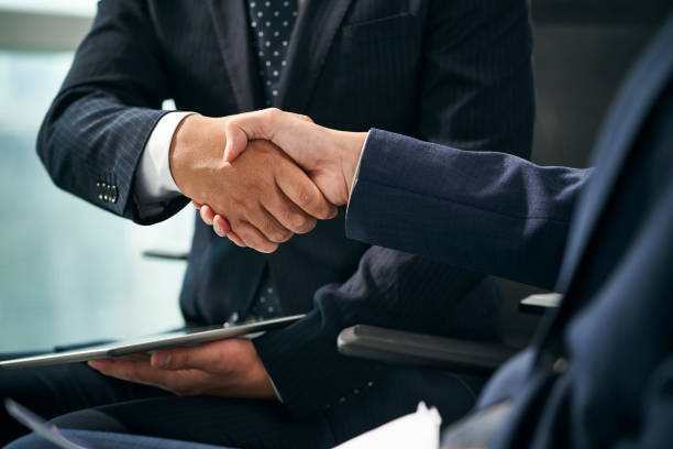istock two asian businessmen shaking hands in office 1479913623