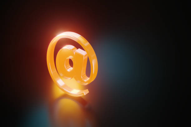 Orange at symbol glowing on black background. Horizontal composition with copy space.