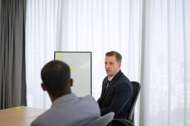 Collaborative process of multiethnic business people team working together discussing, researching, brainstorming and planning work at business meeting workplace in modern office building