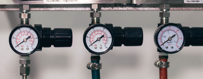 Pressure gauge on a gas regulator in a laboratory analytical equipment.
