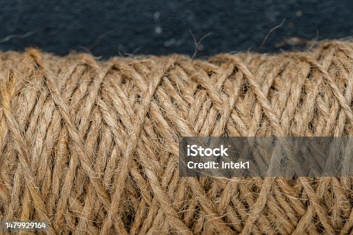 istock Natural jute twine skein, closeup. Spool of linen rope texture on background 1479929164