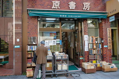 Tokyo, Japan - March 7, 2023: A man shopping for books at a second-hand bookstore in the Jinbocho neighborhood of Tokyo, Japan.