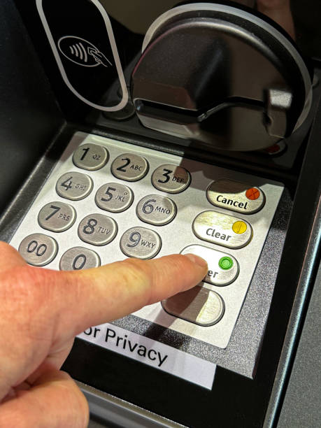 istock Close-up image of unrecognisable person pressing button with index finger on ATM keypad, entering cashpoint PIN number, cash machine card reader and speaker button, elevated view, focus on foreground 1479940579