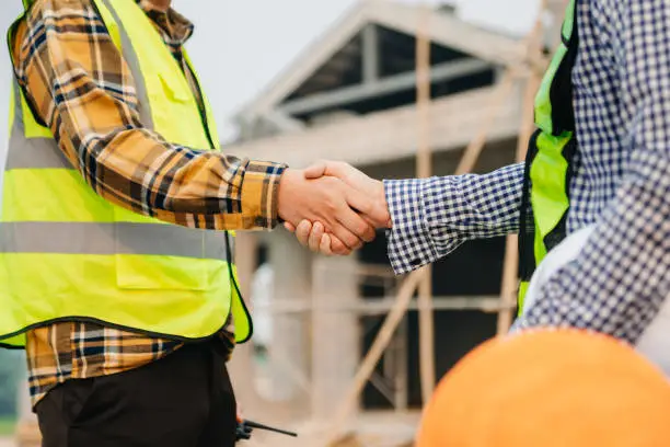 Photo of Engineer and contractor join hands after signing contract,They are having a modern building project together. successful cooperation concept