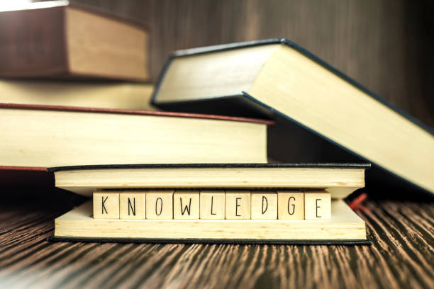 istock Knowledge text in book, education learning concept with opening book or textbook in old library, stack piles of literature text academic archive on reading desk and aisle of bookshelves in school study class room background 1479944903