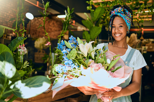Black woman with bouquet, flowers and florist in greenhouse, small business owner and smile in portrait. Happiness, nature and entrepreneur with floral arrangement, Spring and vision with leadership