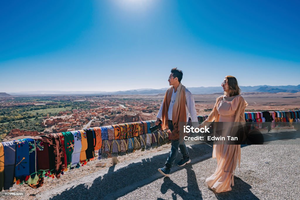 Asian Chinese couple tourist looking at a view from high angle hill side at Tinghir, Morocco Asian and Indian Ethnicities Stock Photo