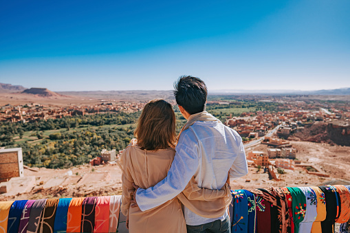 Asian Chinese couple tourist looking at a view from high angle hill side at Tinghir, Morocco