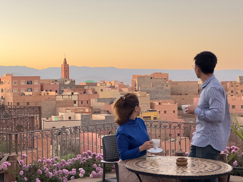 Asian Chinese couple tourist enjoying coffee in the morning at boumalne dades morocco