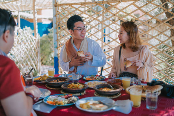 asian chinese tourist enjoying moroccan food at tinghir restaurant patio outdoor dining  patio - shade people patio meat imagens e fotografias de stock