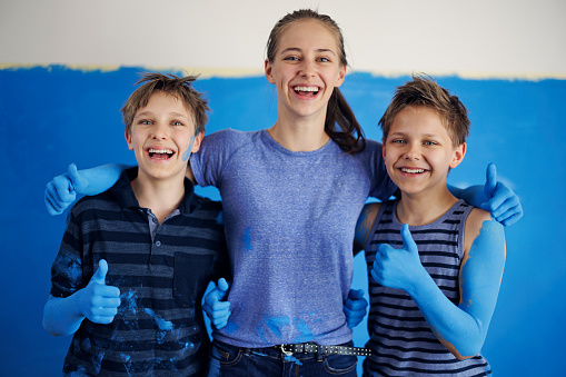 Portrait of three teenage kids helping in house renovation. The kids are dirty with blue paint. 
Shot with Canon R5