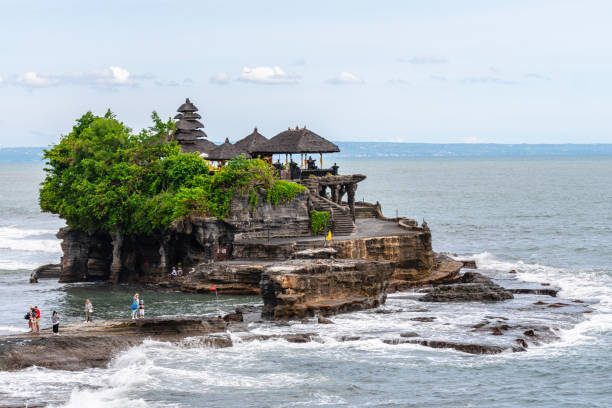 views of pura tanah lot isolated by water tide tanah lot indonesia. 3rd march, 2023: the temple sits on a large offshore rock which has been shaped continuously over the years by the ocean tide tanah lot temple bali indonesia stock pictures, royalty-free photos & images