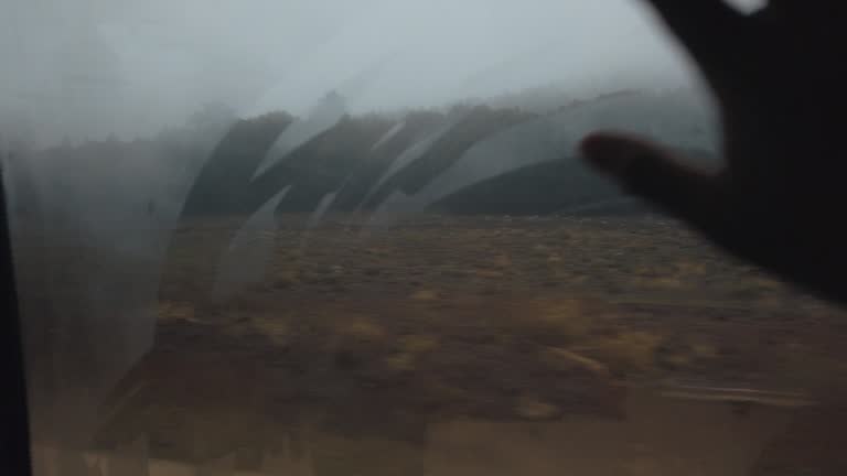 Traveling on the road looking through car window Morocco rural area in the rain from inside car
