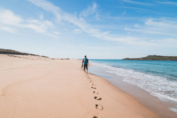 istock Passionate backpacker, backpack and boots in hand, walks along the Praia da Ilha do Pessegueiro beach on the Atlantic Ocean near Porto Covo, Portugal. In the footsteps of Rota Vicentina 1479971504