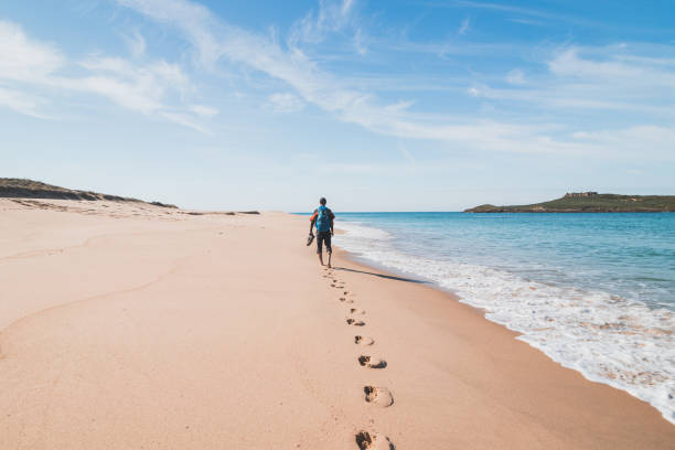 istock Passionate backpacker, backpack and boots in hand, walks along the Praia da Ilha do Pessegueiro beach on the Atlantic Ocean near Porto Covo, Portugal. In the footsteps of Rota Vicentina 1479971513
