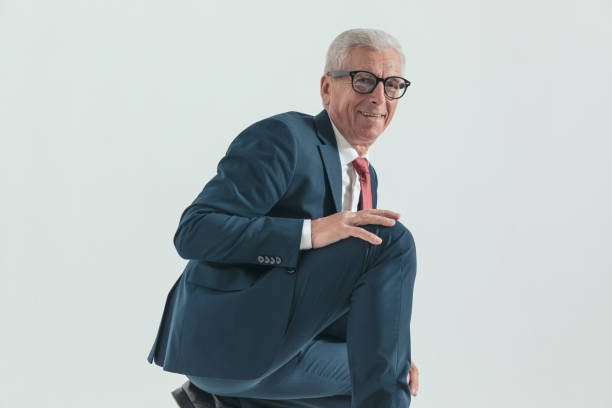 istock side view of happy old man crouching and touching knee with palms 1479971618