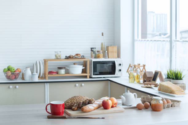 istock Modern kitchen with bread and apples on table near the windowModern kitchen with bread and apples on table near the window 1479973475