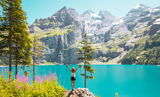 Happy woman hiker in Swizterland,  turquoise lake and alps mountain