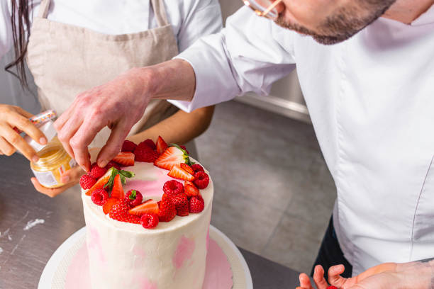 istock Colombian Pastry Chef. Two chefs working on a strawberry and raspberry cake 1479974589